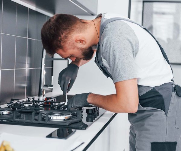 young-professional-plumber-in-grey-uniform-working-resize.jpg